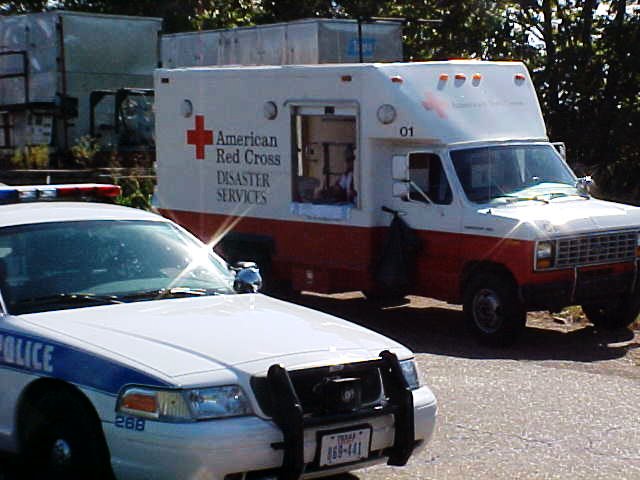 Red Cross Disaster services van sits behind a police cruiser.